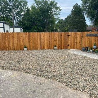 Gravel yard with wooden fence and planters, offering a tranquil outdoor space.