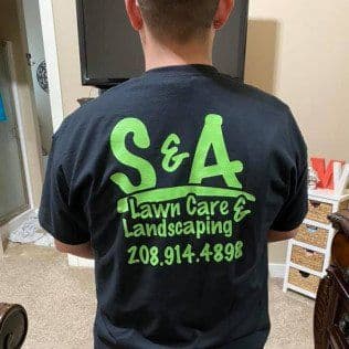 Person wearing a black S&A Lawn Care & Landscaping shirt with contact details on the back.